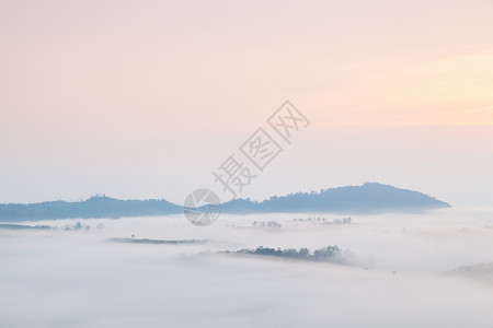 曾是早晨寒冷的清晨雾笼罩山岳和树木太阳升起图片