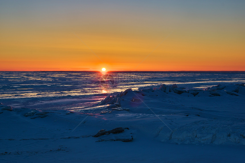爱沙尼亚帕努Parnu完全冰冻的波罗海以日落为颜色在2月阳光明媚和寒冷的夜晚以鲜艳颜色呈现日落彩红的前景黄昏图片