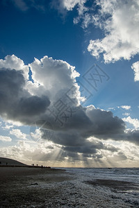 天空积云遮盖海面上空的云层与日光束灰色的图片