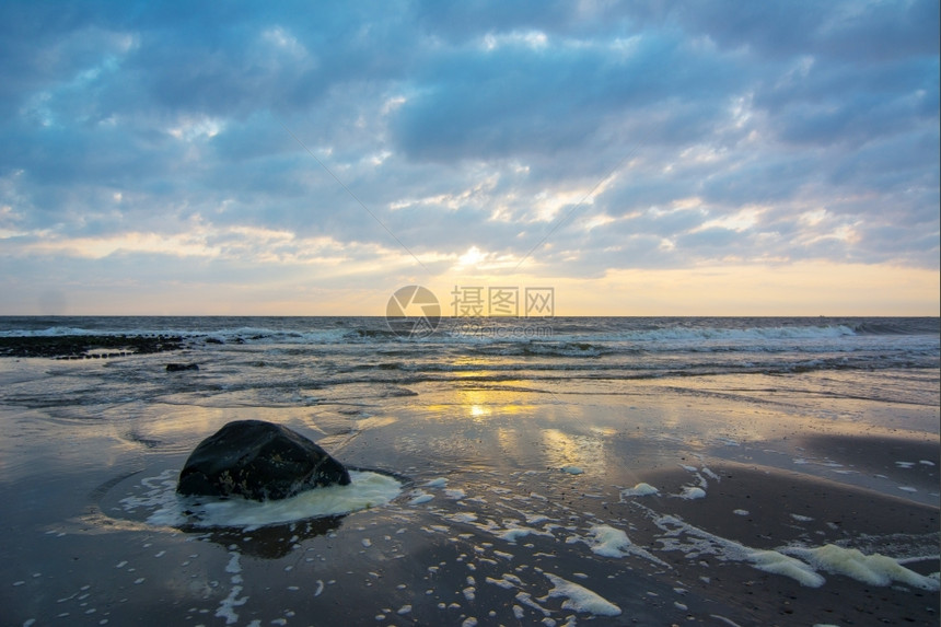 白色的多于荷兰海滩上日落天空飞艳海洋图片