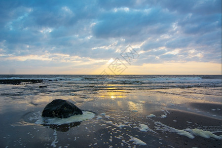 白色的多于荷兰海滩上日落天空飞艳海洋喜怒无常高清图片素材