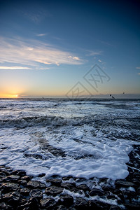 积云防波堤荷兰海滩上日落天空飞艳气象天气高清图片素材