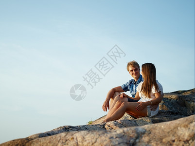 坐着男人天空小情侣坐在悬崖上蓝天坐在背景上图片