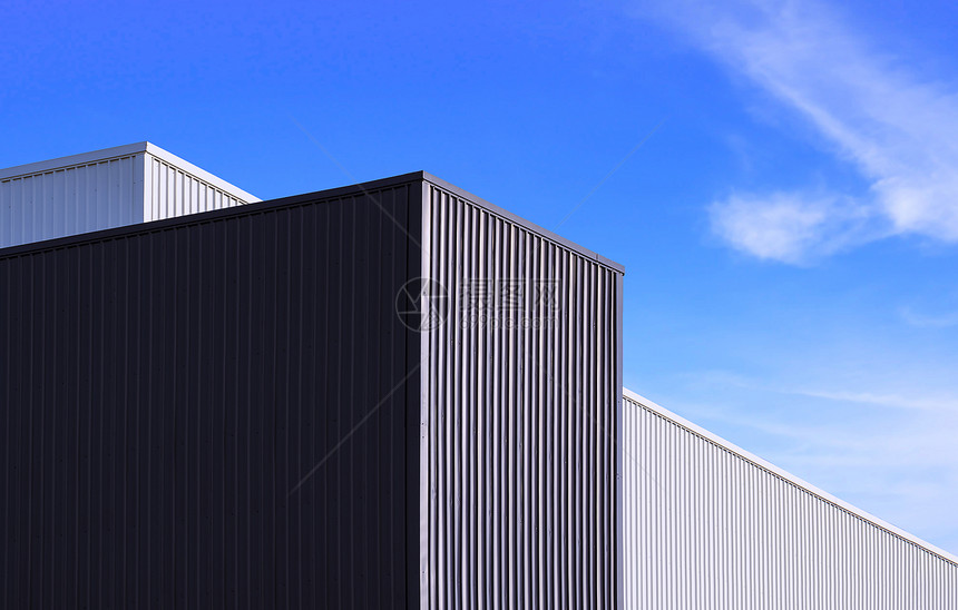 当代的黑色和白金属工厂建筑在蓝色天空背景下的低角度视图以蓝天背景为现代的白色图片