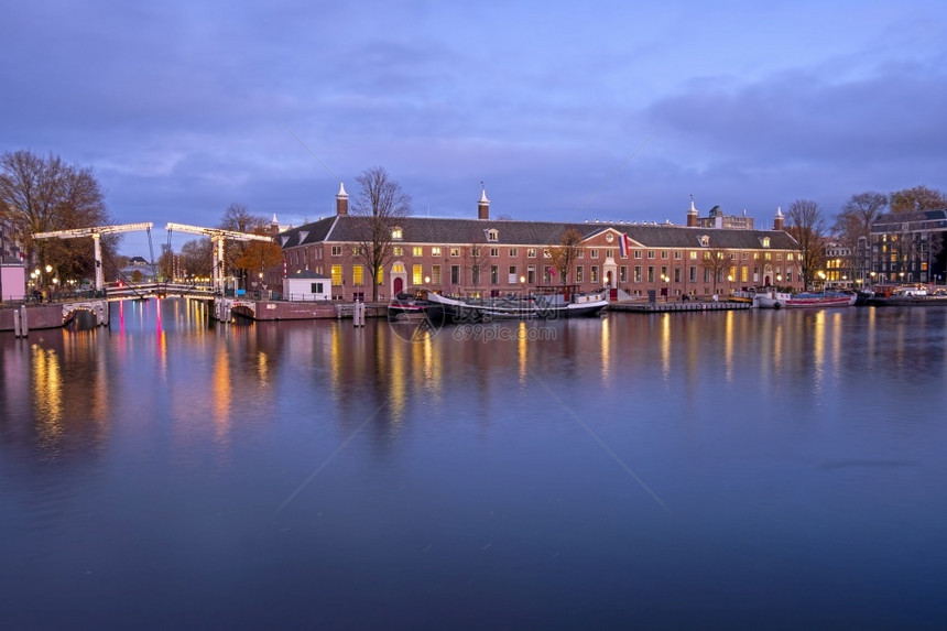日落时在荷兰阿姆斯特丹尔河市风景传统的住宅水图片