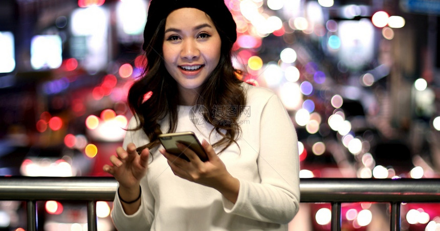 保持美丽的年轻亚洲女在夜间使用手机的户外肖像画女青年聪明的孩图片