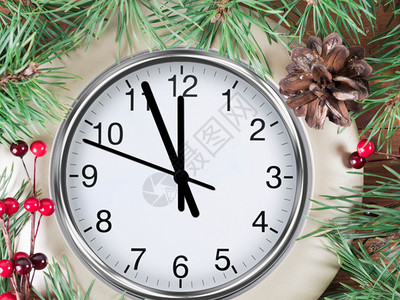 包装传统新年在白雪下受装饰的圣诞树下雪上有花环和圣诞装饰的时钟图片