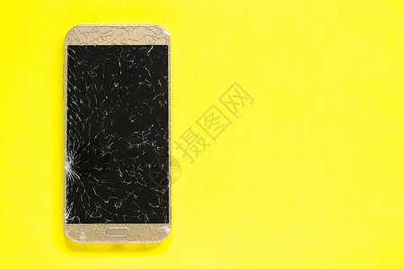 手机玻璃黄色背景上的断裂缝合移动电话概念复制空间之顶视图黄色背景上的断裂孔径移动电话概念复制空间之顶视新的小工具高清图片素材