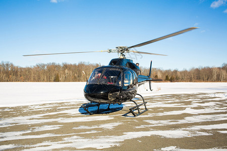 蓝天的单黑色直升机冬季雪蓝色天空的单黑直升机和雪独奏航班下的背景图片