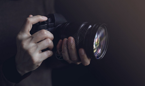 语气女青年摄影师使用相机拍摄片黑暗的托调选择手掌焦点专业的拍照图片