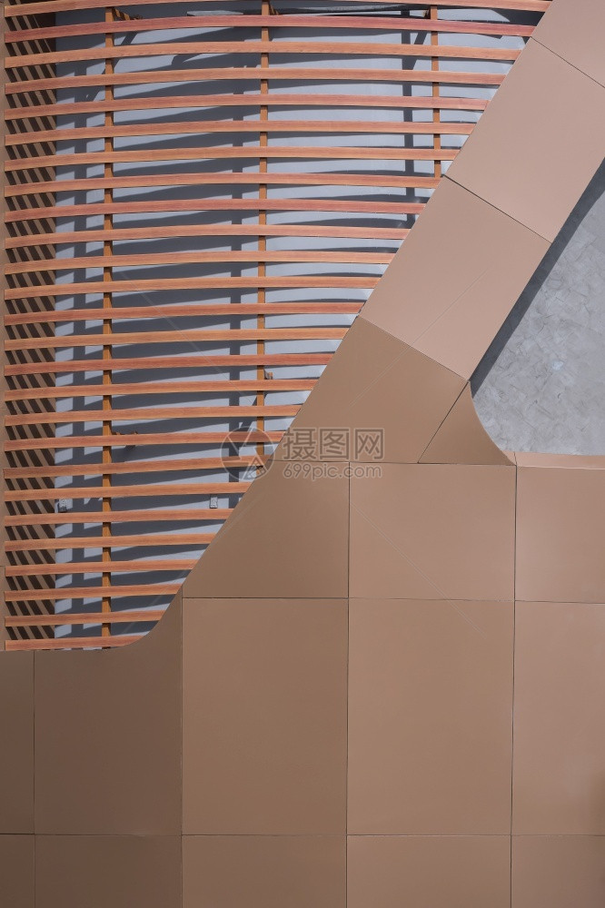建筑学垂直框架现代建筑物曲线墙壁上棕色铝合复砖块的人工木抽象形态图案垂直框建造外部的图片