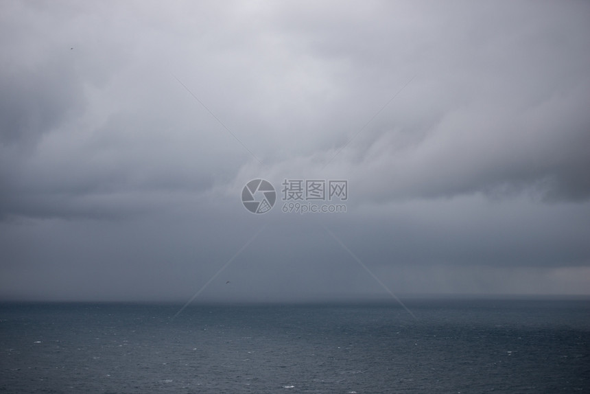 黑色的激烈海洋背景有雨云海洋背景地平线上有云和雨多的图片