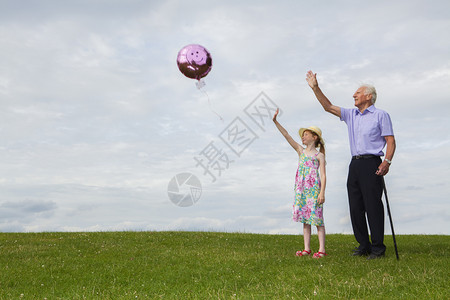 启发自由白种女孩和她的祖父放出一个气球在天空中梦图片