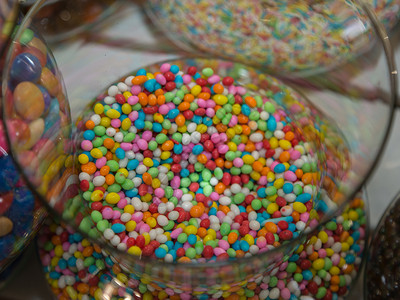 透明玻璃容器内的彩色纸屑糖果透明玻璃容器内的彩色纸屑糖果甜点的红色图片