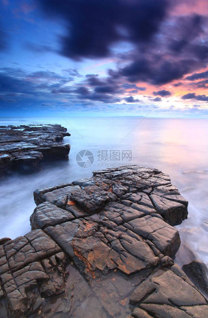 黄昏海岸线的美丽岩石图片