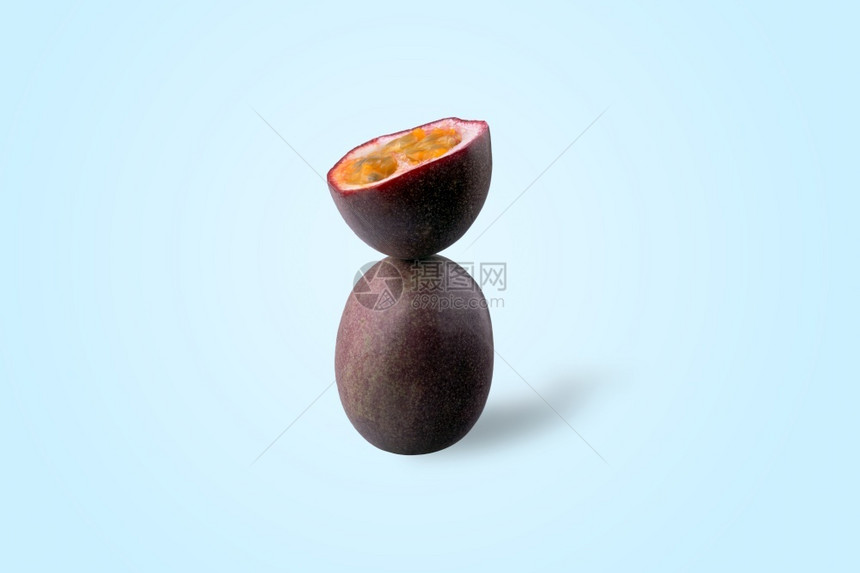 马拉基亚一半切片激情果实平衡在一片蓝底的激情果实上素食主义者水果图片