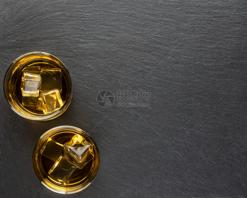 科涅克白兰地木板两杯威士忌黑色背景上加冰来自石板两杯威士忌黑色背景上加冰瓶子图片