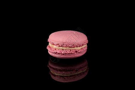 黑色的背景上多彩的粉色红毛松法国糕点图片