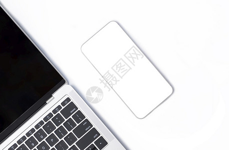 白色桌面上有部分黑笔记本电脑的白色智能手机模型顶部视图个人的屏幕键盘图片