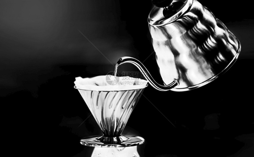 咖啡倒在上热水从黑背景的茶壶里灌满了热水潮人酿造杯子图片