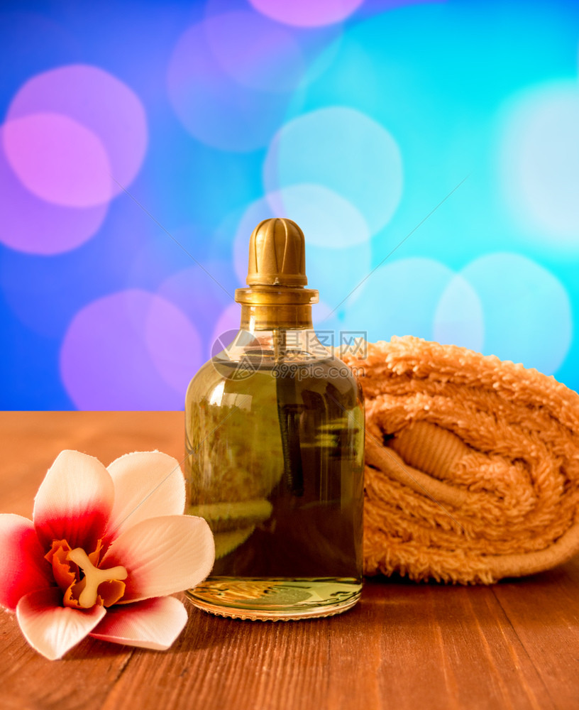 准备用于SPA和健康卷毛巾一瓶油和花兰在木制背景上托勒瓶装油和花兰在木制背景上传统的禅化妆品图片