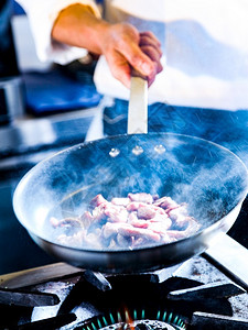 人美食厨师在房烹饪食物师准备在炒锅中煎炸食物行动图片