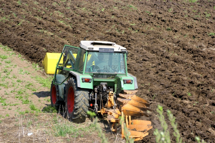 农田场地在春天耕种土的绿色拖拉机械图片