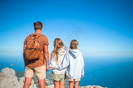 女儿户外日落山上父亲和孩子的幸福家庭山上走着四口人的家庭快乐图片
