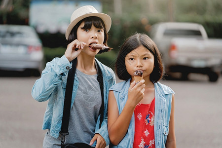 童年两个女孩在公园散步时街上吃冰淇淋甜的乐趣夏天高清图片素材
