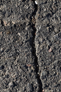 道路黑色表面的大裂缝在自然因素的影响下沥青破碎以及工匠作环境差的裂缝表层材料运输风化瓦解高清图片素材