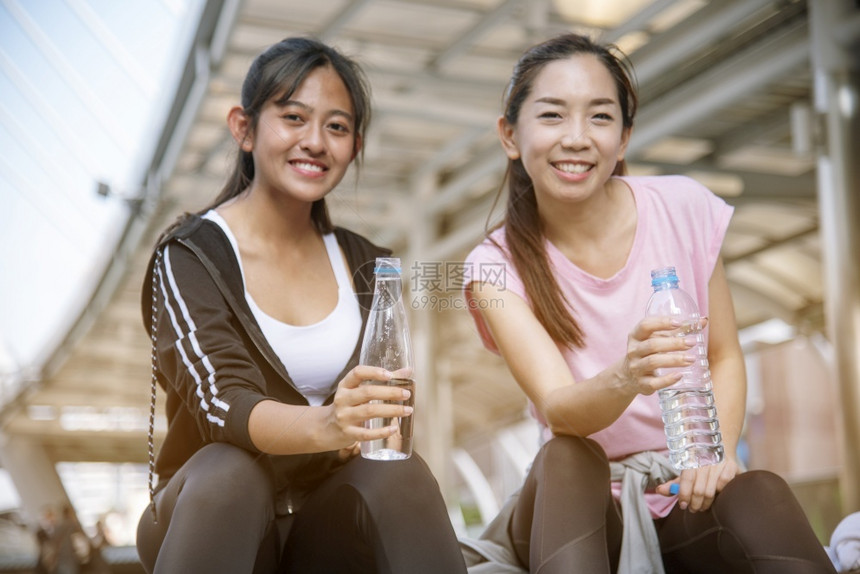桥外部女在运动后饮用现代城市的矿泉水在年轻女户外锻炼时身穿健康运动服并超越健康生活方式的女概念在健康生活方式之外进行户锻炼喝图片