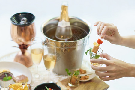 女人在鸡尾酒派对上手握着不同的零食和开胃菜餐厅早午脑袋自助餐高清图片素材