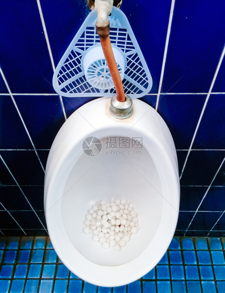 老的管道撒尿公共洗手间中带有青蛙球的肮脏小便池图片