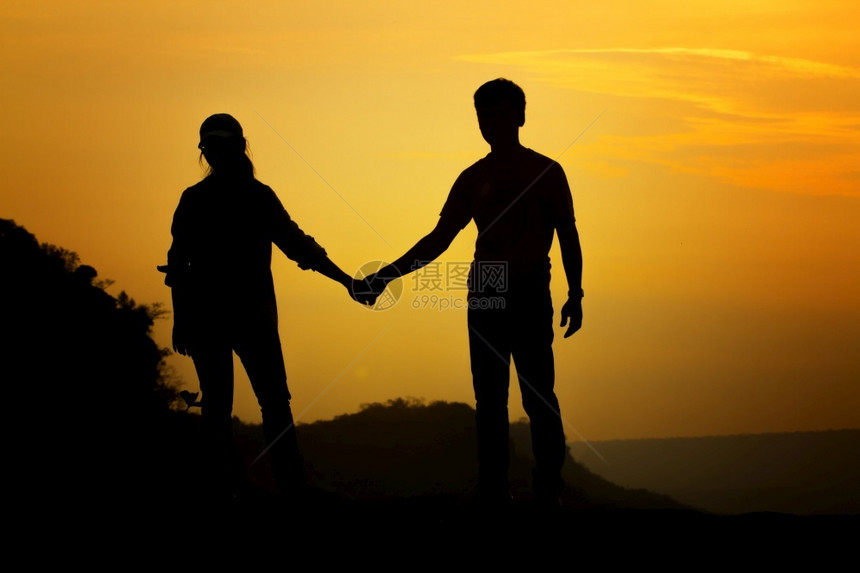 日出时为旅行者牵手的双对角男朋友年轻的为了图片