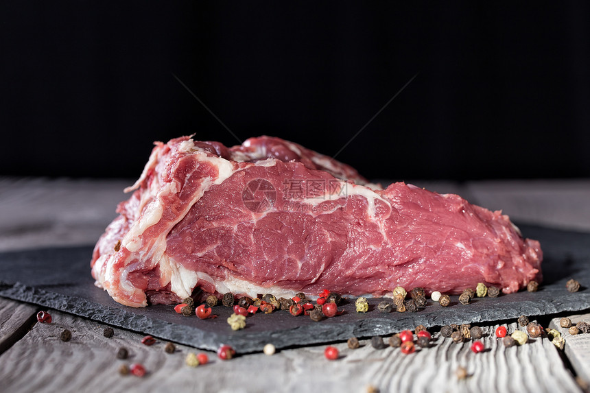 生的切割木板一块新鲜的牛排肉餐桌上有辣椒烹饪和健康饮食的概念一块新鲜的牛排烤肉桌子上有牛排图片