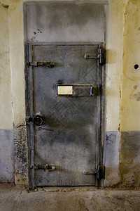 锈生的封闭式金属监狱门在室内图片