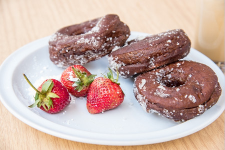 结霜圆圈糖巧克力甜圈新鲜草莓和冰咖啡甜的图片