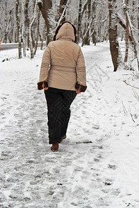 女霜一个人独自在寒冬公园户外游走客图片