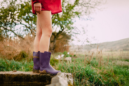 用红色雨衣和水靴把女孩的腿关在户外鸡皮疙瘩紫色的青春痘图片