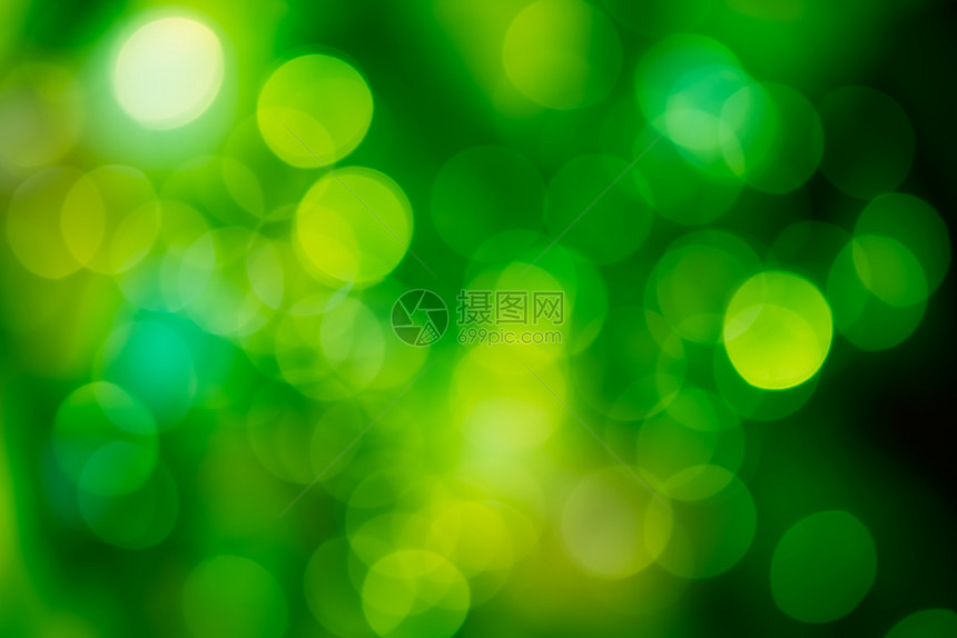 生动圣诞节回转鲜艳的绿色翡翠背景上的明亮圆形光散景鲜艳的绿色翡翠背景上的明亮圆形散景图片