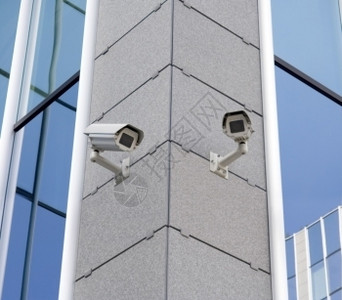 两台监视摄像头挂在楼角监视器随附的财产图片