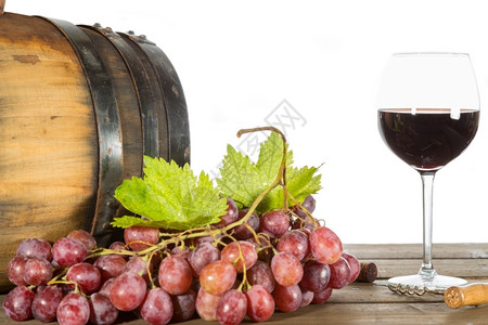 一杯红酒加些葡萄和橡木桶浮子束白色的图片