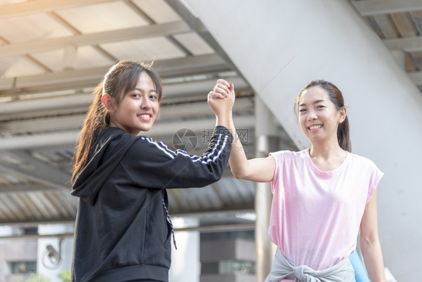 跑晴天在现代城市运动的妇女穿着健康运动服在青年女子户外健身锻炼练习在阳光明亮媚的外野运动健康的生活方式女概念健康妇女桥图片