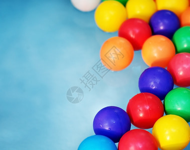 俏皮圆形的玩蓝水背景下儿童泳池中的塑料彩球儿童泳池中的塑料彩球图片