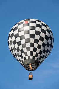 黑色和白气球飞向蓝天空黑和白气球飞向明亮的翱翔蓝色背景图片
