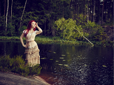 夏天森林穿着裙子的迷人年轻女站在水线边背面湖身着洋装吃水线图片