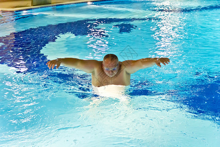 湿的大胖子在游泳池里玩运动蓝色的老年图片