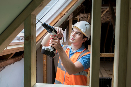 人们水平的职业使用钻井安装更换窗口的建筑工人Drill图片