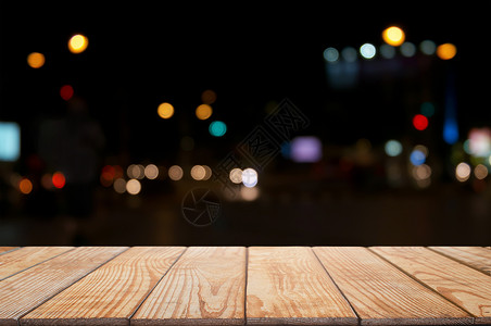 桌子丰富多彩的在模糊混合夜间市场前的空木桌bokeh背景抽象的图片