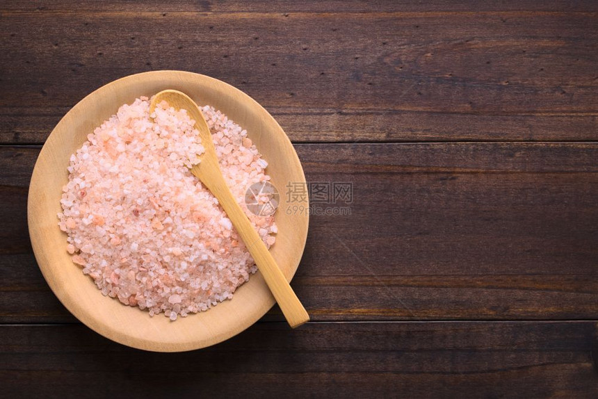 烹饪桌子自然用木勺制成的板上粗糙粉红色喜马拉雅盐在上方拍摄了相片侧面有复制空间图片